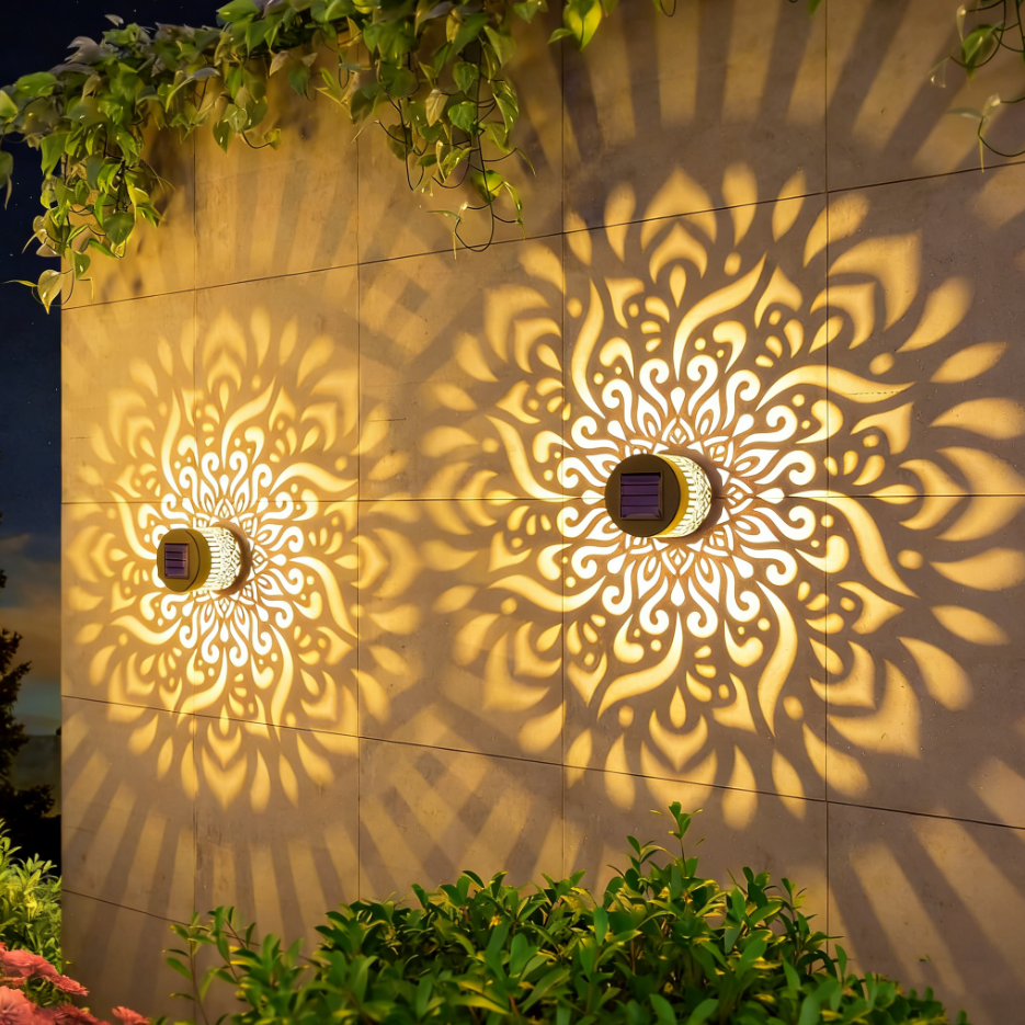 Două lămpi solare decorative montate pe perete, proiectând mandale de lumină caldă